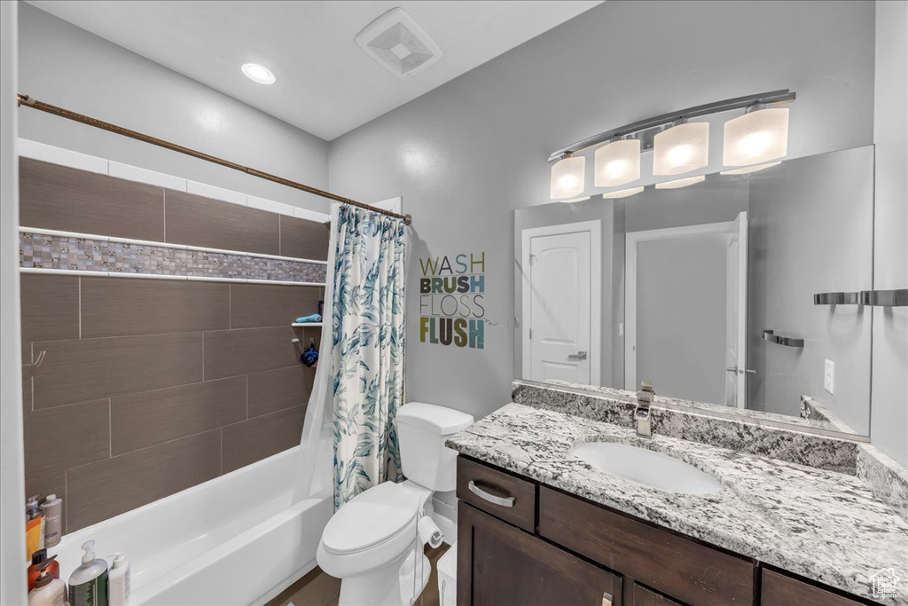 Bathroom featuring vanity and shower / tub combo with curtain