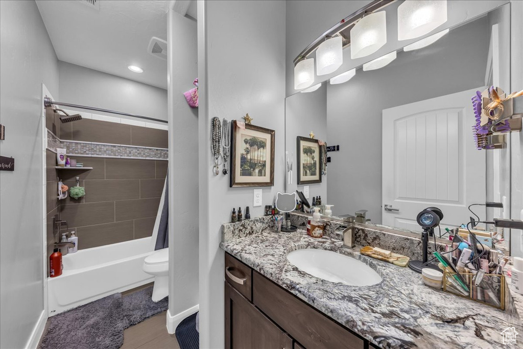 Bathroom featuring vanity, shower / bath combination with curtain, and wood finished floors