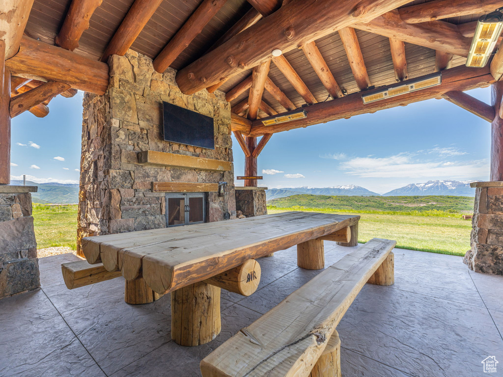 View of patio / terrace featuring an outdoor stone fireplace and exterior bar