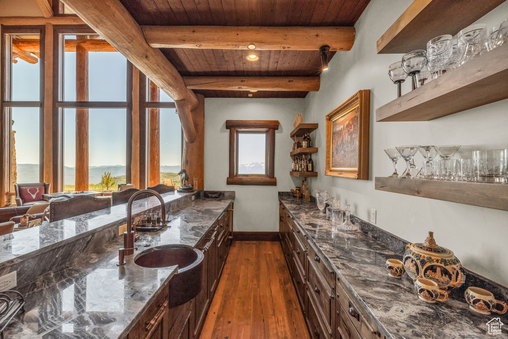 Indoor wet bar with a wood ceiling with exposed beams and dark wood-type flooring
