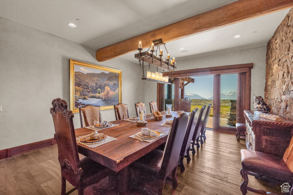 Dining space with beam ceiling, hardwood / wood-style floors, recessed lighting, and a chandelier