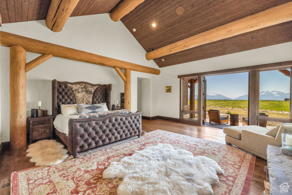 Bedroom featuring a mountain view, access to exterior, wood finished floors, recessed lighting, and a wooden ceiling with exposed beams