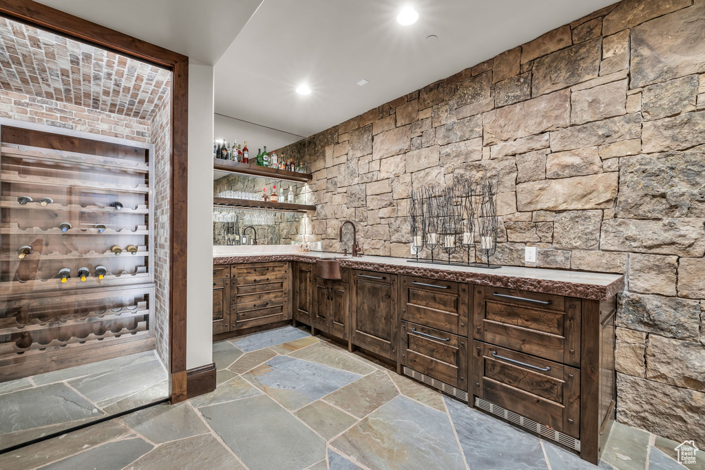 Indoor wet bar with light stone finish flooring and recessed lighting