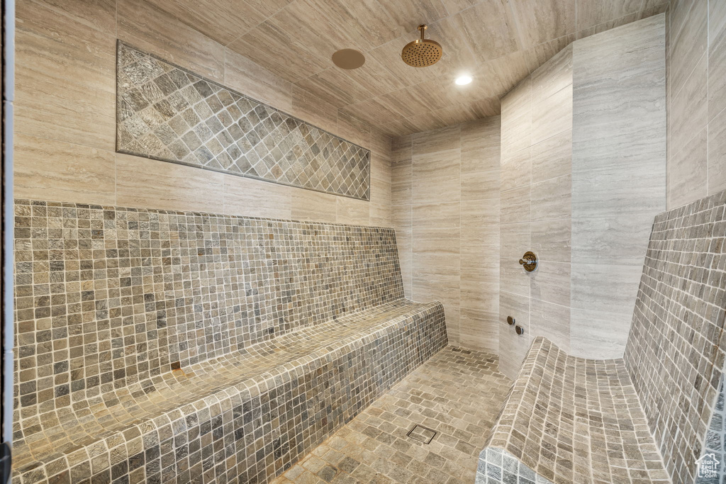 Full bathroom with a relaxing sauna, a tile shower, and tile walls