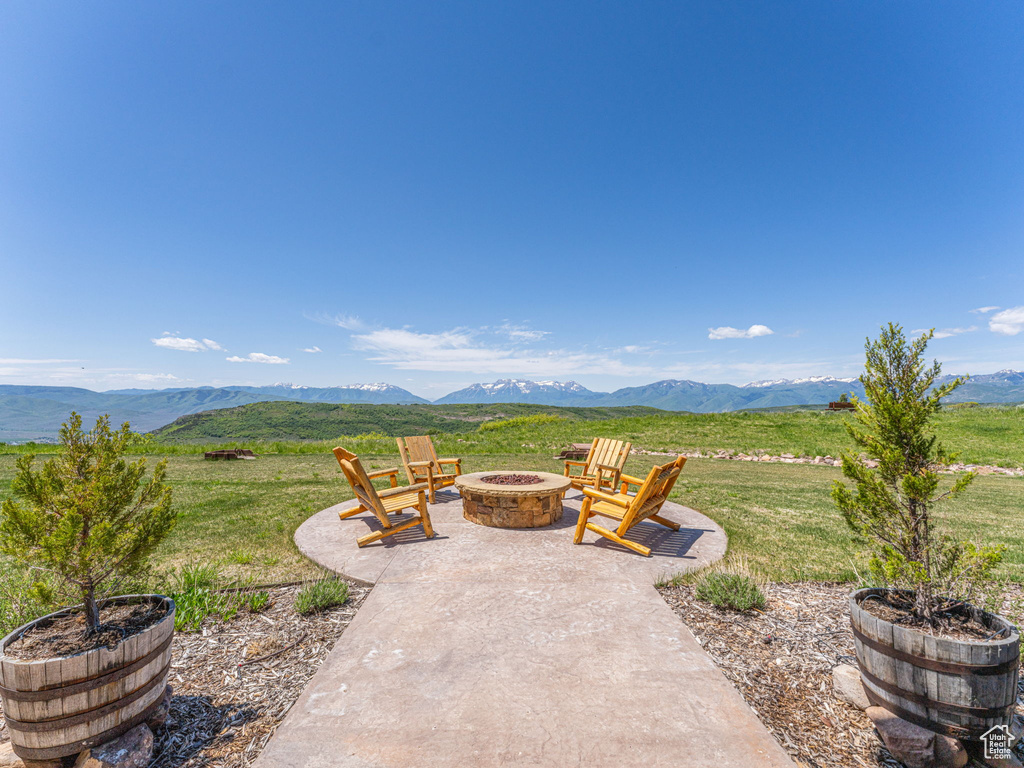 View of patio with a fire pit and a mountain view