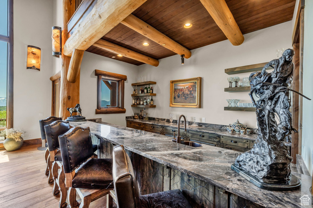 Indoor wet bar with a wooden ceiling with exposed beams, wood finished floors, and recessed lighting