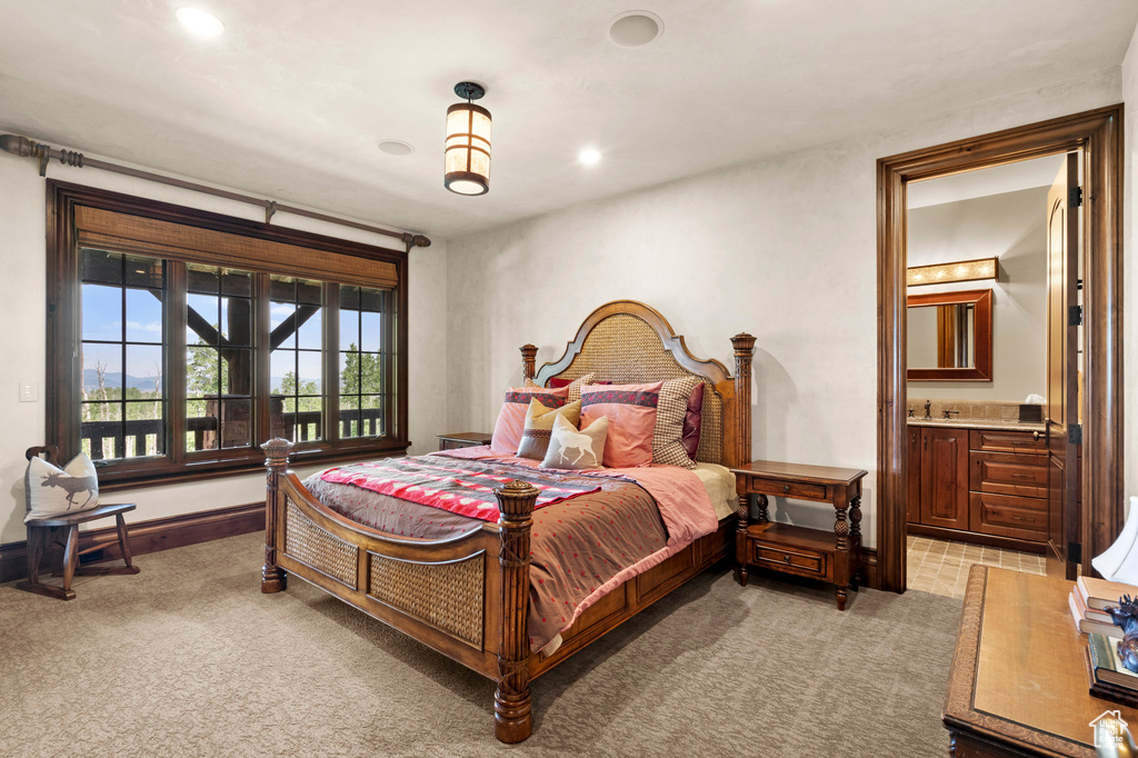 Bedroom with light colored carpet, ensuite bath, and recessed lighting