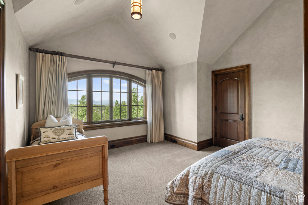 Carpeted bedroom featuring vaulted ceiling and baseboards