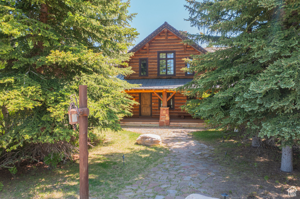 Log home with covered porch and a metal roof