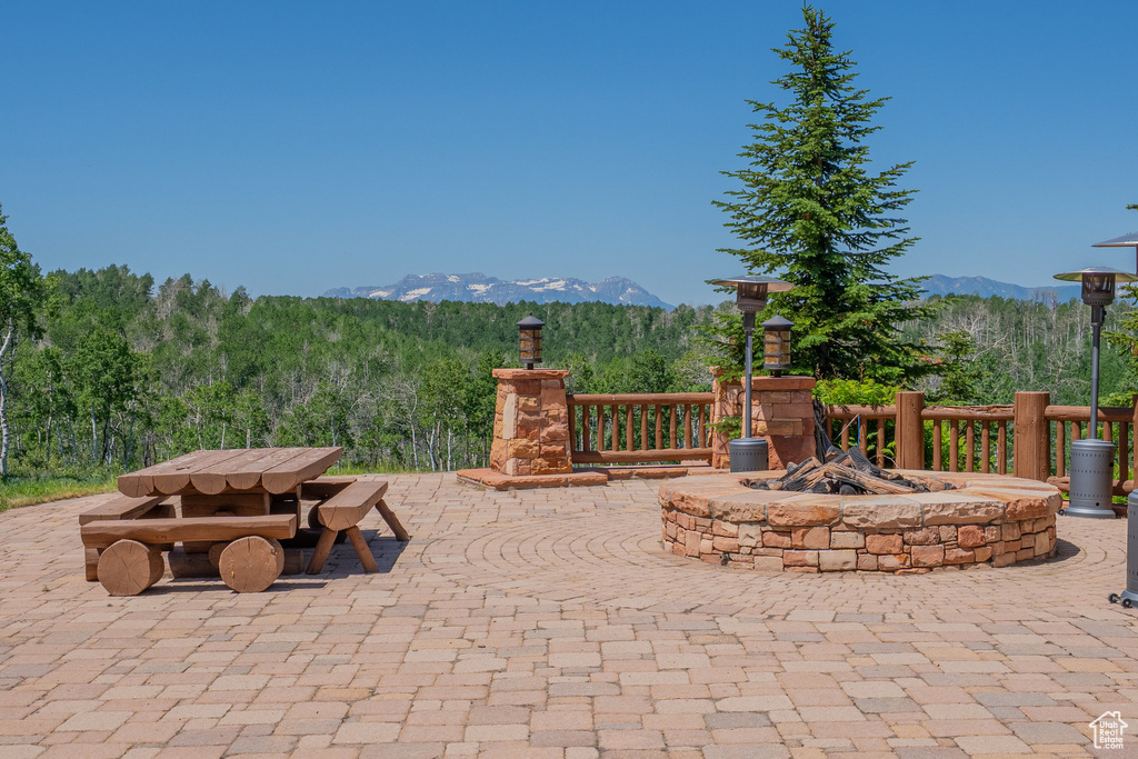 View of patio with a mountain view, an outdoor fire pit, and outdoor dining area