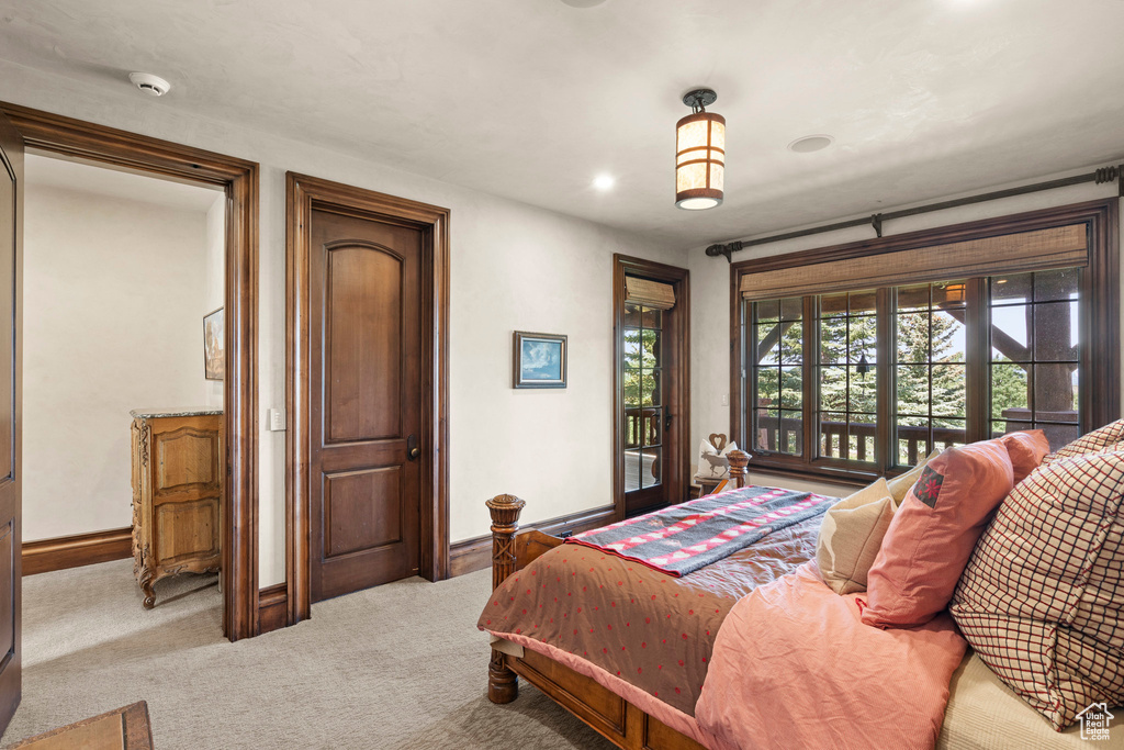 Bedroom with access to exterior and light colored carpet