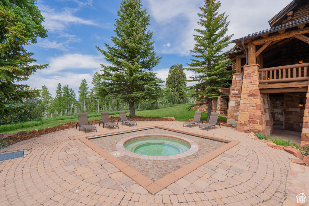 View of swimming pool with an in-ground hot tub and a patio area
