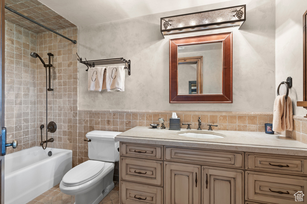 Full bathroom featuring shower / washtub combination, vanity, and tile walls