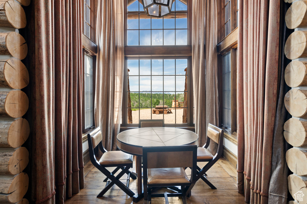 Dining area with a towering ceiling and hardwood / wood-style floors