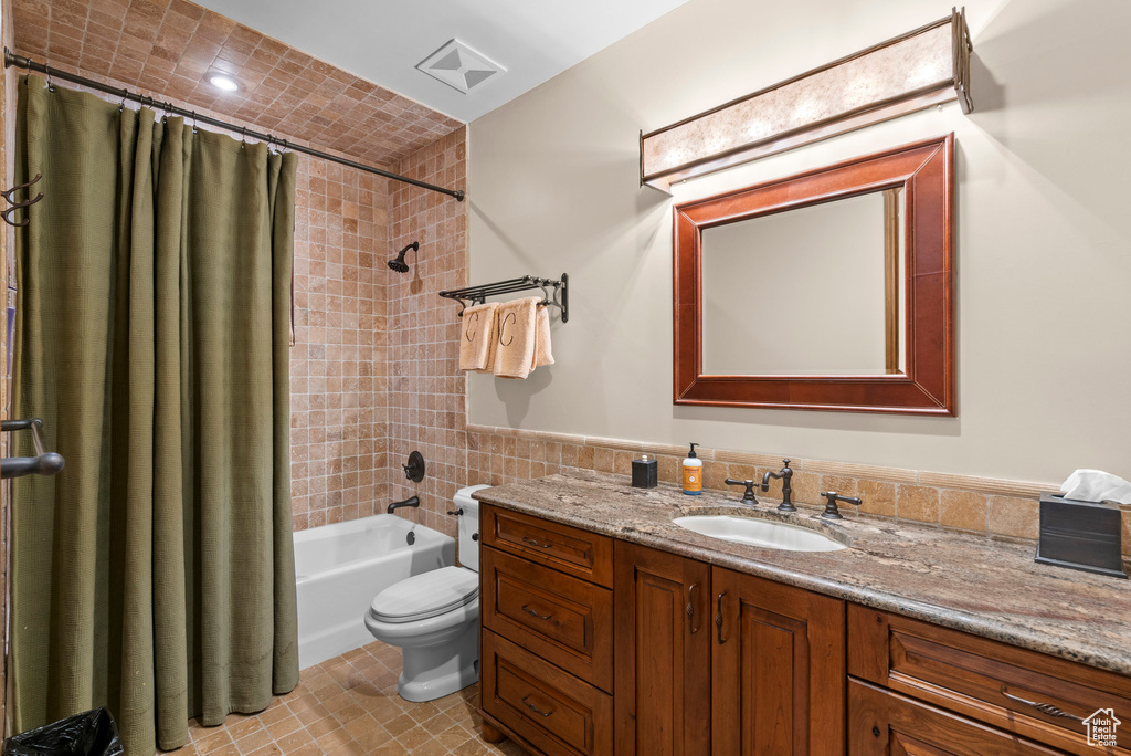 Bathroom featuring vanity, shower / bath combo, and tile patterned floors