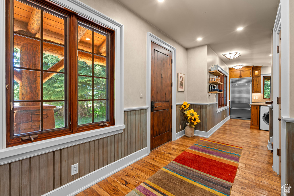 Foyer featuring washer / clothes dryer, wainscoting, light wood-style floors, and recessed lighting