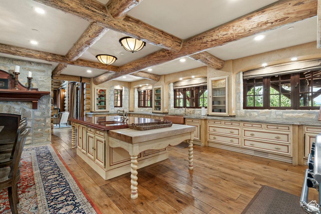 Recreation room with light wood-style flooring, beamed ceiling, coffered ceiling, recessed lighting, and a fireplace