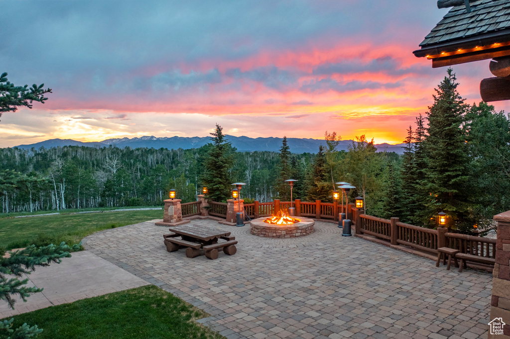 View of patio featuring a fire pit, a mountain view, and a wooded view