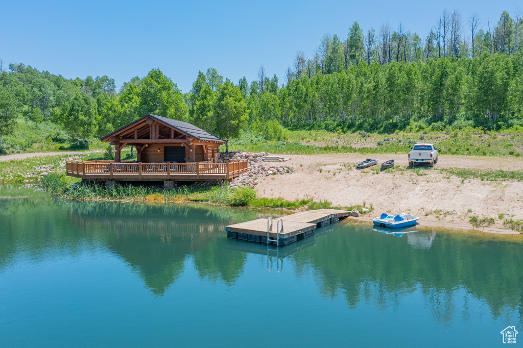 Dock featuring a water view, a forest view, and a gazebo