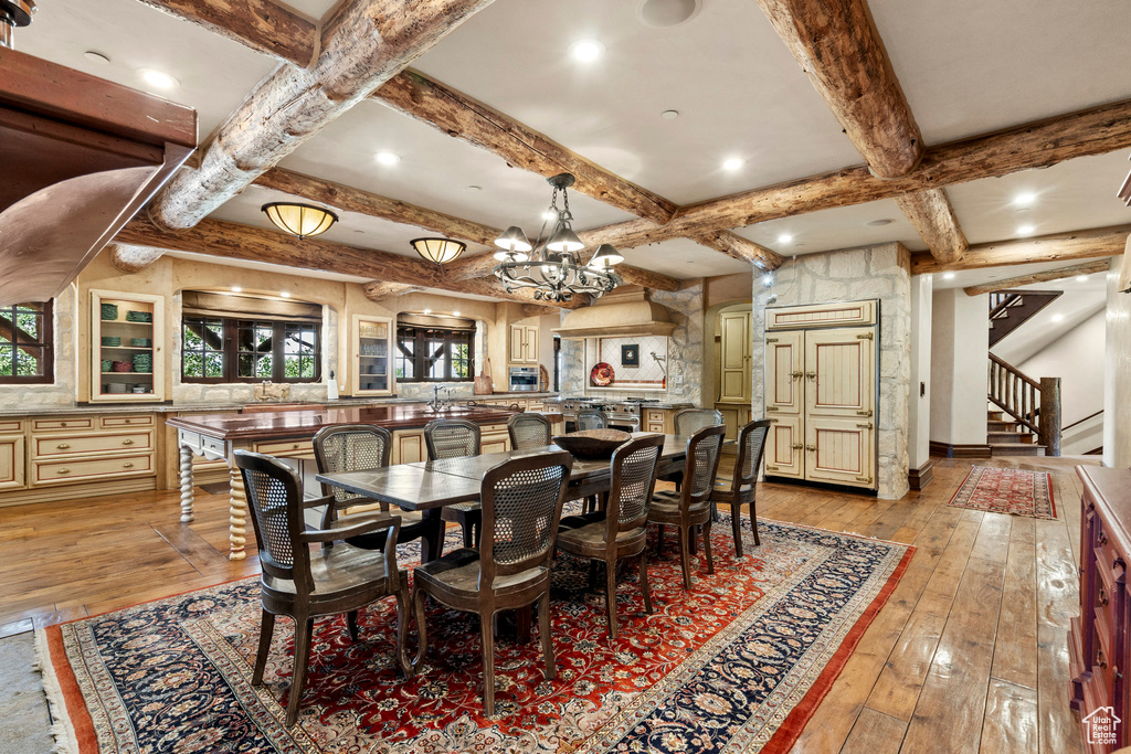 Dining area featuring light wood-style floors, stairway, coffered ceiling, a chandelier, and beam ceiling