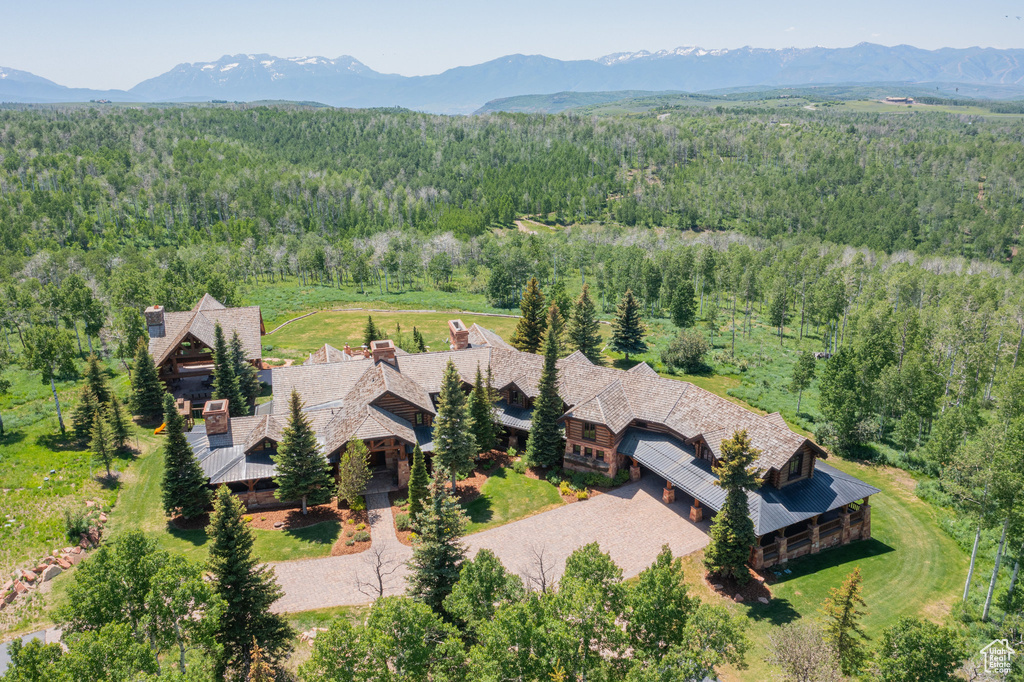 View from above of property featuring a forest and a mountain backdrop