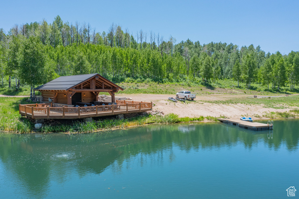 Dock area with a water view and a wooded view