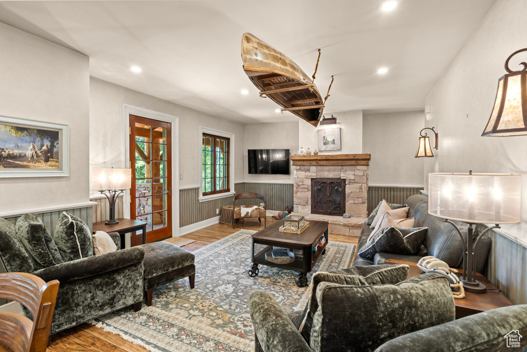 Living area with wood finished floors, wainscoting, a fireplace, and recessed lighting
