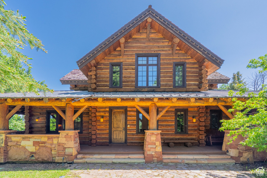 View of front of property featuring log siding and covered porch