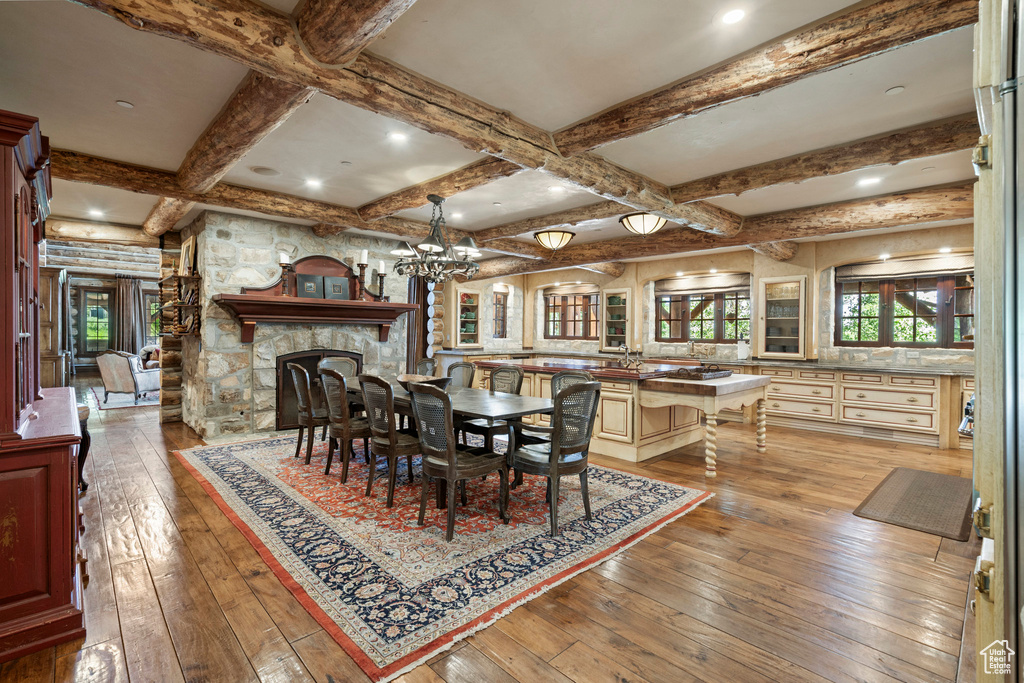 Dining area with hardwood / wood-style flooring, beam ceiling, a chandelier, coffered ceiling, and recessed lighting