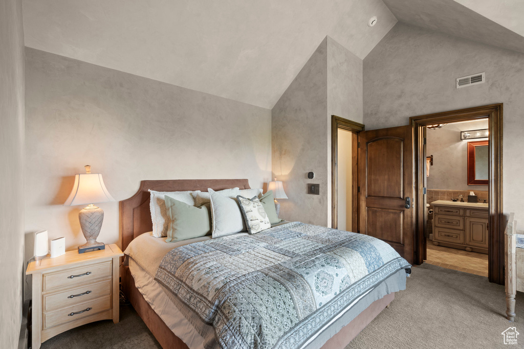 Bedroom with light colored carpet and high vaulted ceiling