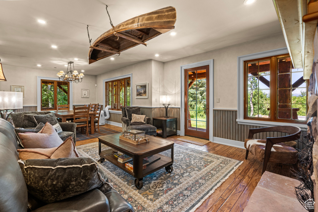 Living area featuring wainscoting, hardwood / wood-style flooring, a chandelier, and recessed lighting