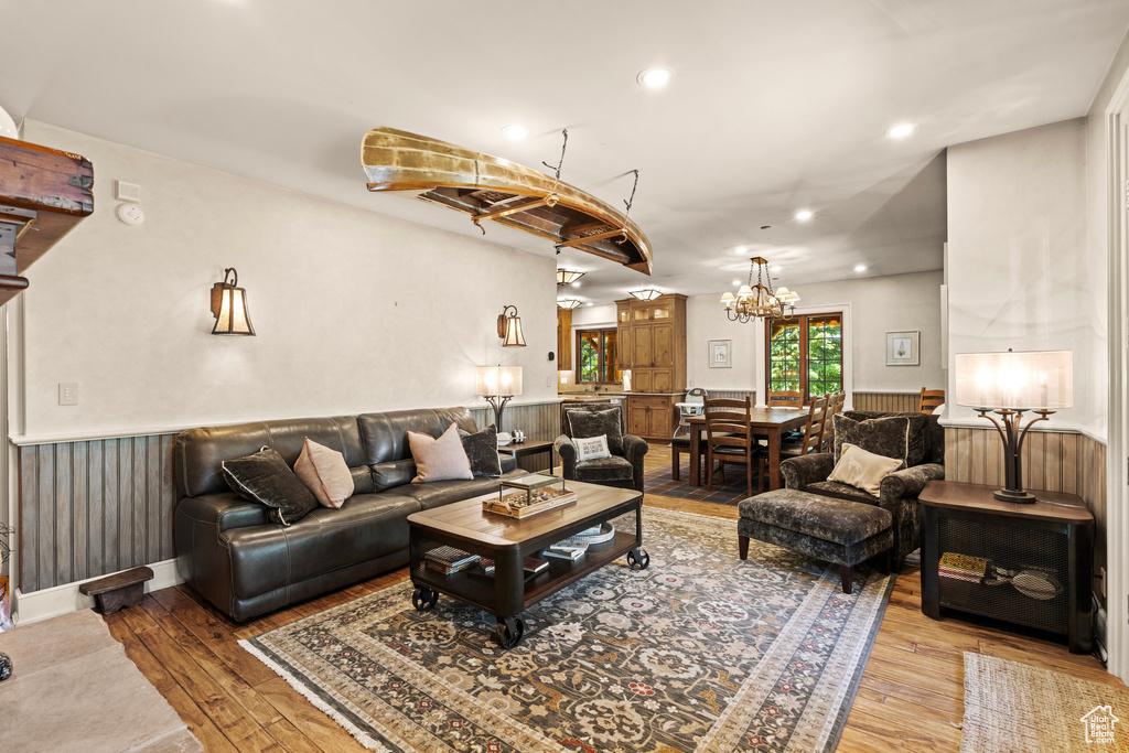 Living area featuring hardwood / wood-style floors, a wainscoted wall, recessed lighting, and a chandelier