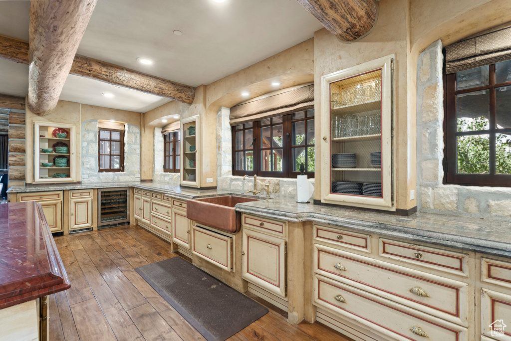 Kitchen featuring wine cooler, hardwood / wood-style floors, beamed ceiling, cream cabinetry, and recessed lighting