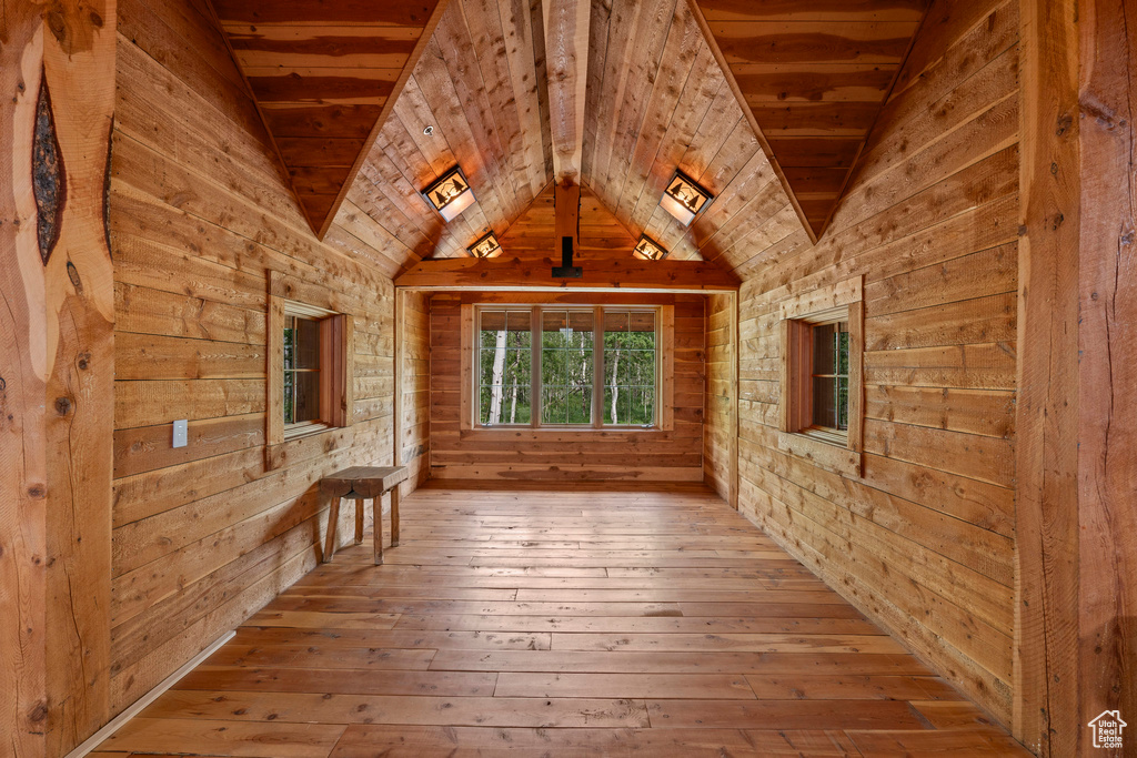Corridor with wooden walls, hardwood / wood-style flooring, lofted ceiling, and wood ceiling