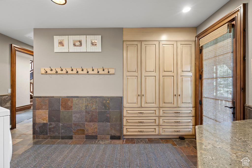 Interior space featuring stone tile flooring, washer / dryer, and recessed lighting