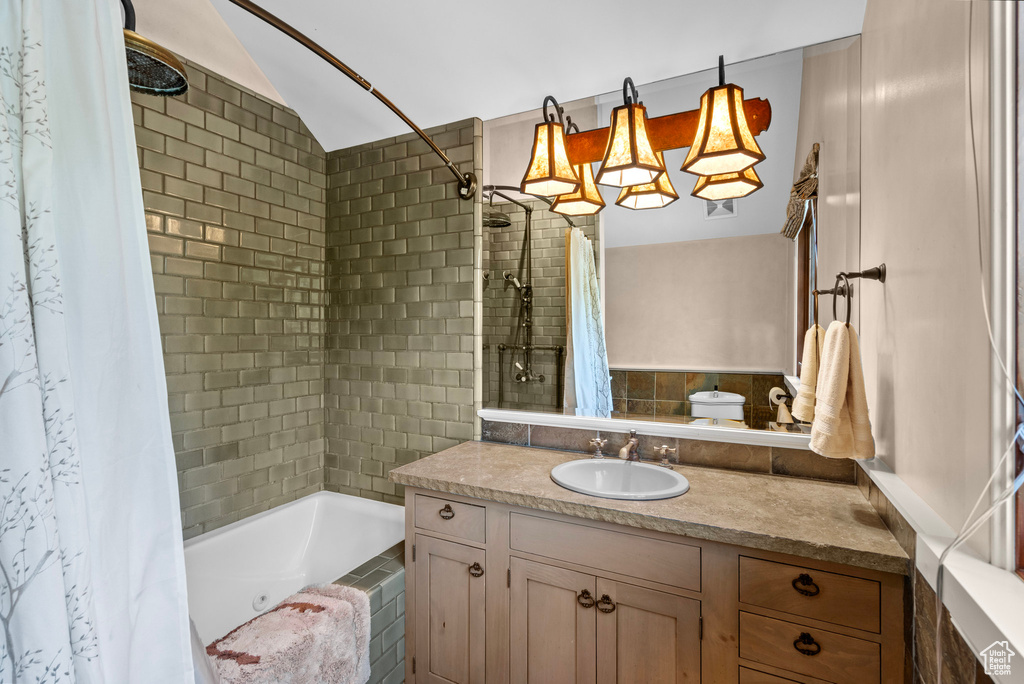 Bathroom with lofted ceiling, vanity, and shower / bath combo with shower curtain