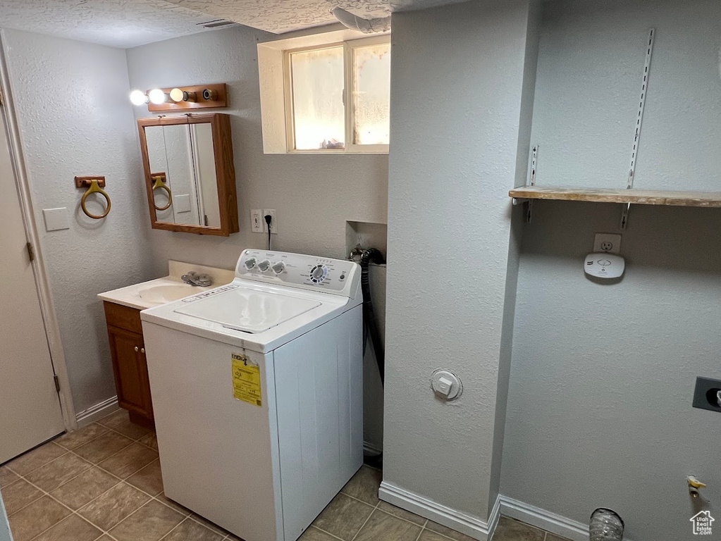 Laundry area featuring washer / clothes dryer and light tile patterned flooring