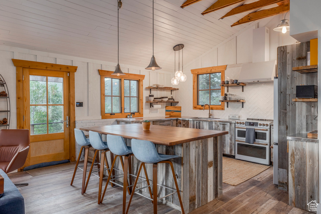Kitchen featuring wooden counters, open shelves, double oven range, light wood-style flooring, and a kitchen bar