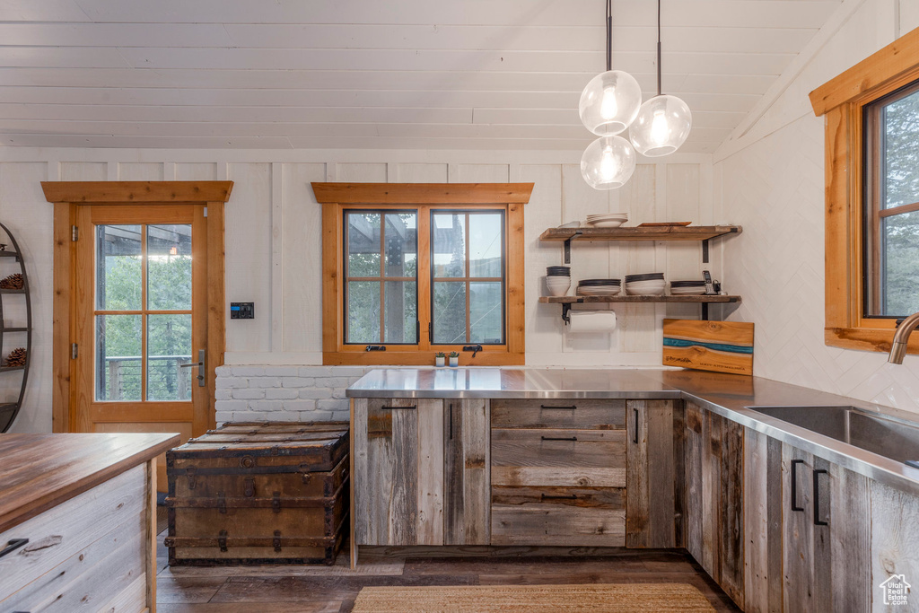 Kitchen with stainless steel counters, dark wood-style flooring, healthy amount of natural light, open shelves, and vaulted ceiling