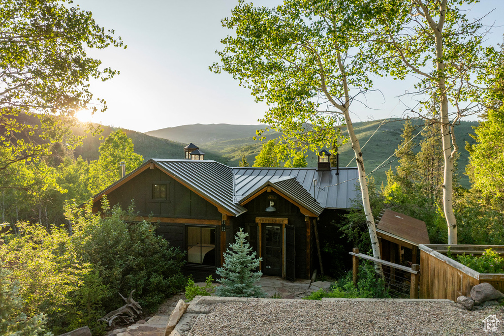 Log home with a standing seam roof, a chimney, a mountain view, a metal roof, and board and batten siding
