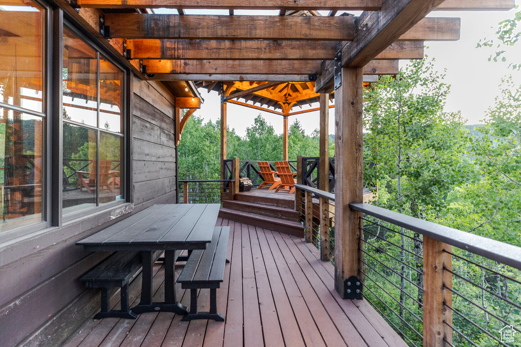 Wooden terrace with outdoor dining area and a pergola