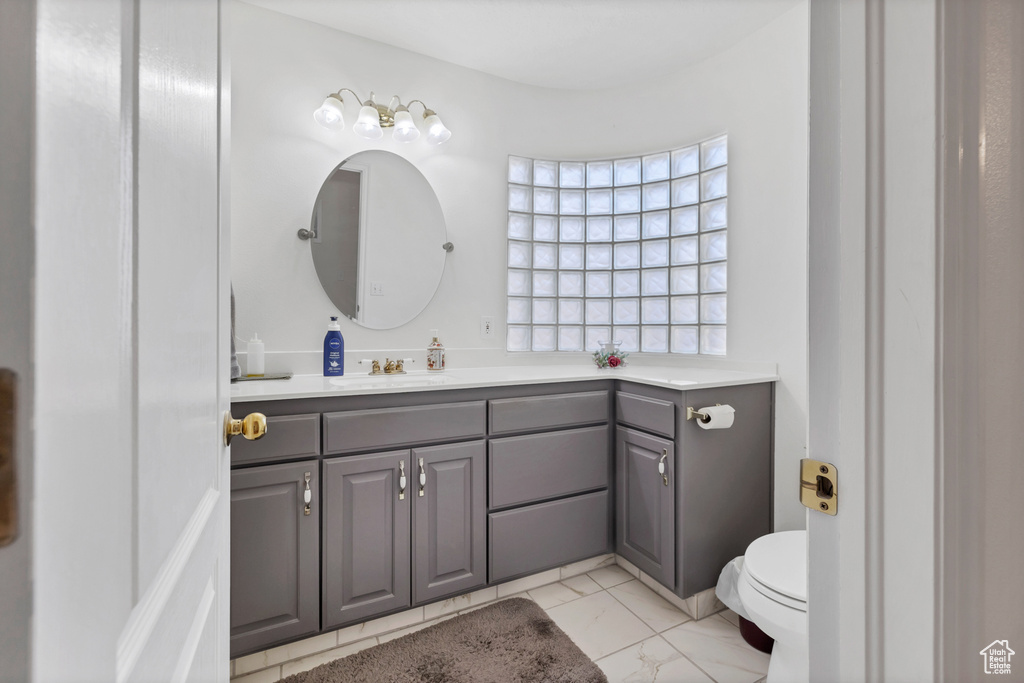 Bathroom featuring vanity and marble look tiles