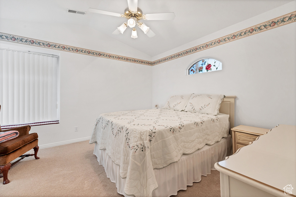 Bedroom featuring lofted ceiling, light carpet, and a ceiling fan