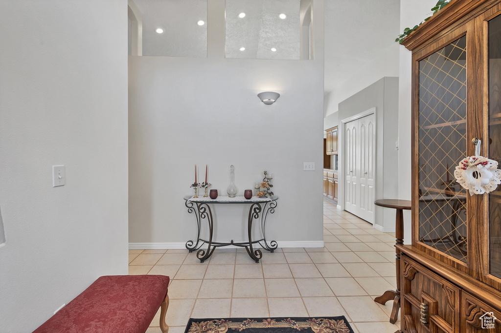 Entrance foyer with light tile patterned floors, a high ceiling, and recessed lighting