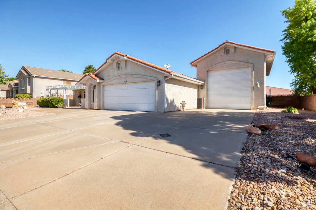 Mediterranean / spanish house featuring driveway, stucco siding, a tiled roof, and a garage