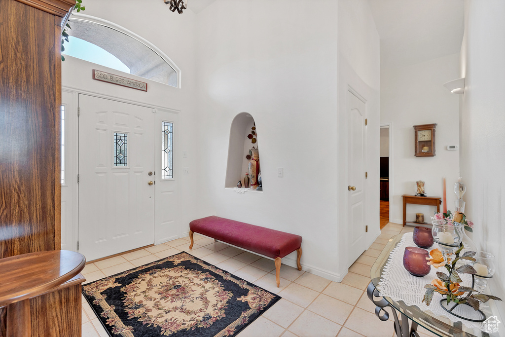 Entrance foyer featuring light tile patterned flooring and a towering ceiling