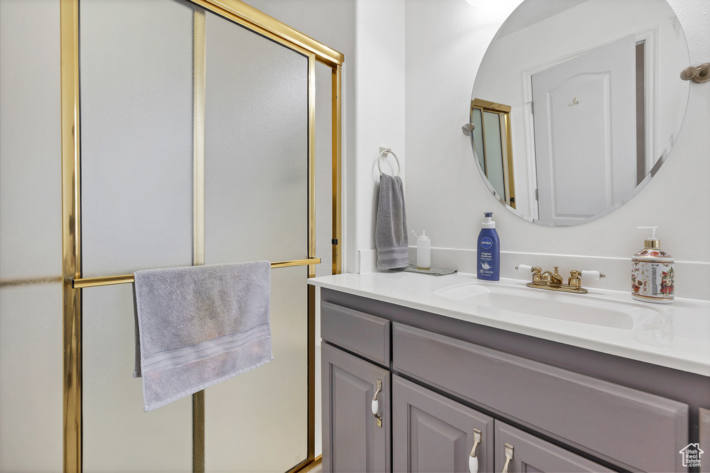 Bathroom with vanity and a shower with door
