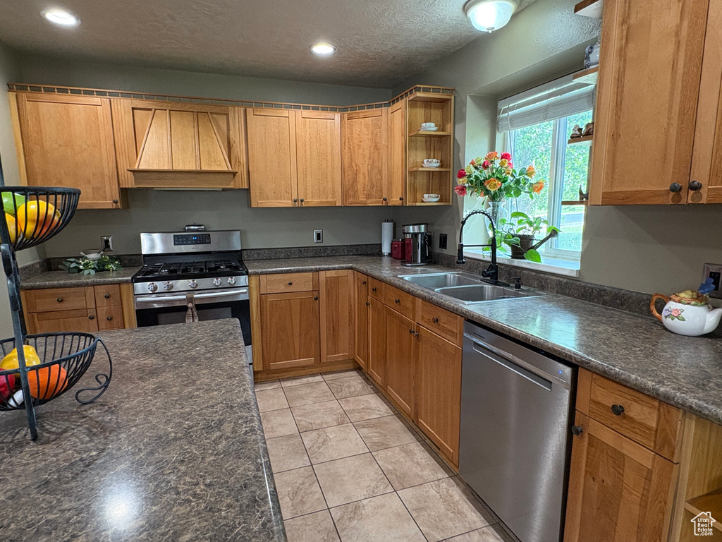 Kitchen with appliances with stainless steel finishes, custom range hood, open shelves, dark countertops, and recessed lighting