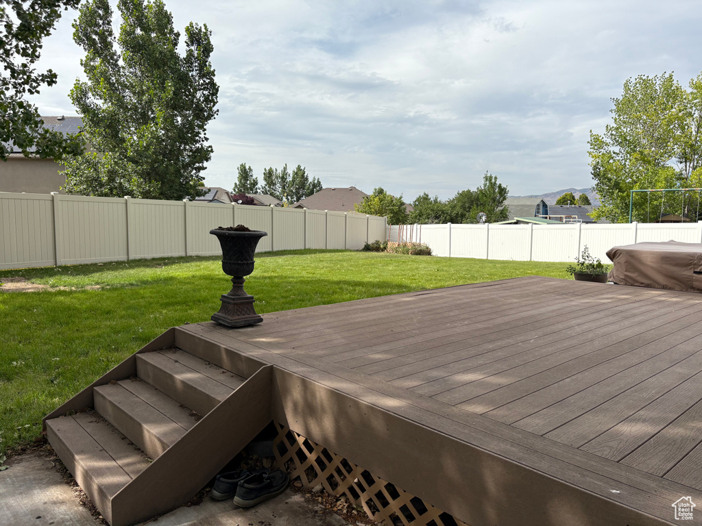 Wooden terrace with a fenced backyard and a mountain view