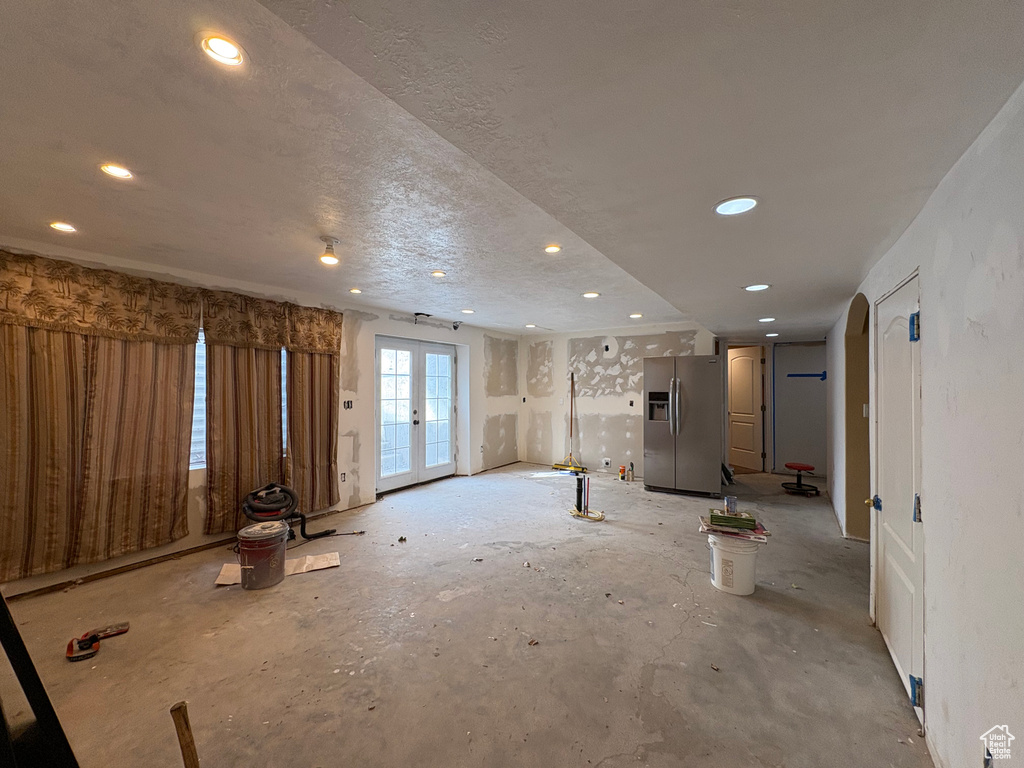 Unfurnished living room featuring french doors and recessed lighting